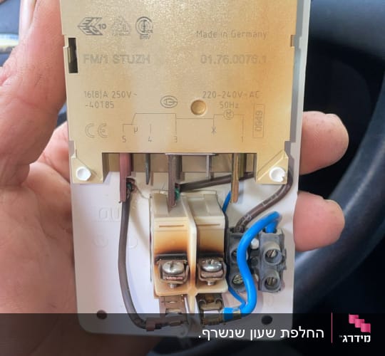רכיב חשמלי עם חיבורים וכבלים ביד אדם